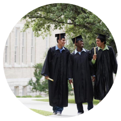 Students in graduation gowns walk on campus