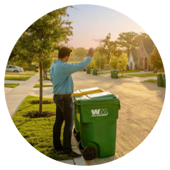 Man waving to his neighbor while leaving waste containers at the curb